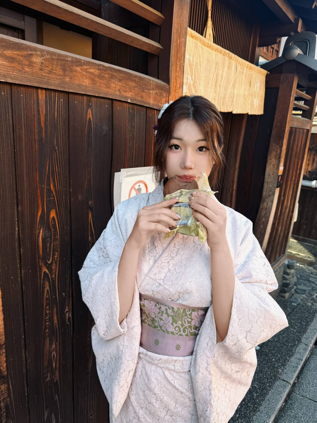 小悦穿着浅色和服站在木质街景前